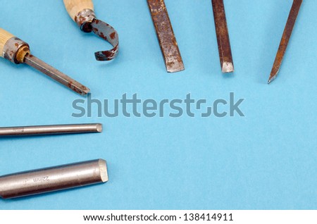 chisel graver carve tools set for wood work on blue background. place for text.