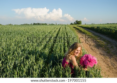 long village sand path and woman sitting with peony flower near rye field
