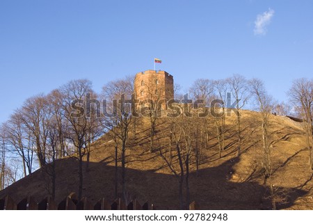 Gediminas castle in Vilnius with Lithuania flag on top of huge hill. Tricolor - yellow, green, red.