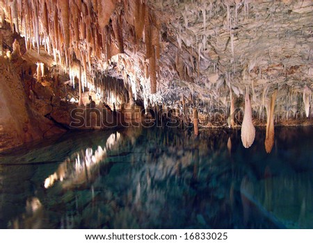 Stalactites hanging over water reservoir inside Crystal & Fantasy caves in Bermuda.