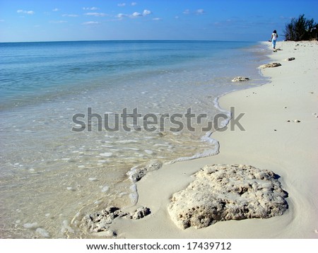 The girl walking along Our Lucaya beach on Grand Bahama Island, The Bahamas.