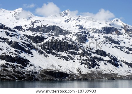 Mountainous snow-covered coast in Glacier Bay national park, Alaska.