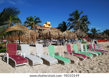 The row of colorful chairs on Mahahual resort town beach (Mexico).