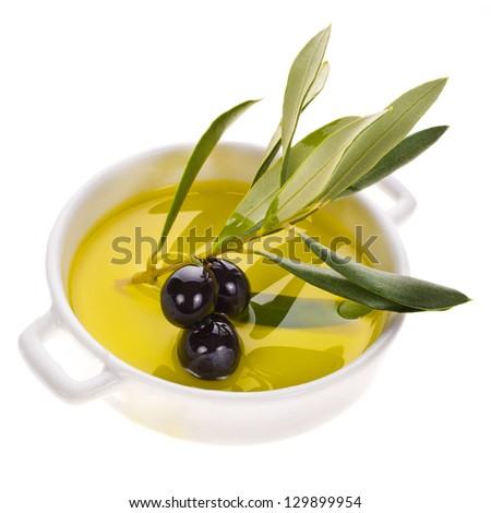 small bowl with olive oil decorated with a small twig with black olives fruit isolated on white background small bowl with olive oil decorated with a small twig with black olives fruit isolated on white background