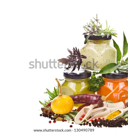 dry spices, fresh herbs and cooking sauces in jars isolated on white background