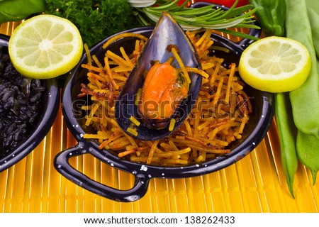 Spanish Mediterranean sea food - noodles in a typical small pan on the yellow mat