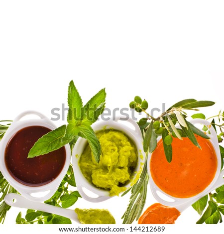 fresh vegetables and herbs and cooking sauces in white bowls isolated on a white background