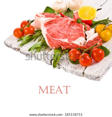 meat, a large piece of fresh meat, beef, to be on the old white boards,  decorated with greens and vegetables isolated on white background