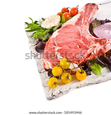 meat, a large piece of fresh meat, beef, to be on the old white boards, decorated with greens and vegetables and bowls with sauces isolated on white background