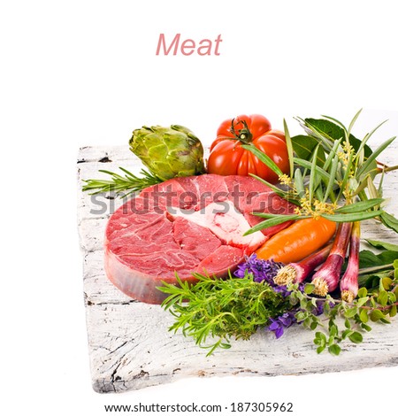 meat, a large piece of fresh meat, beef, to be on the old white boards, decorated with greens and vegetables isolated on white background