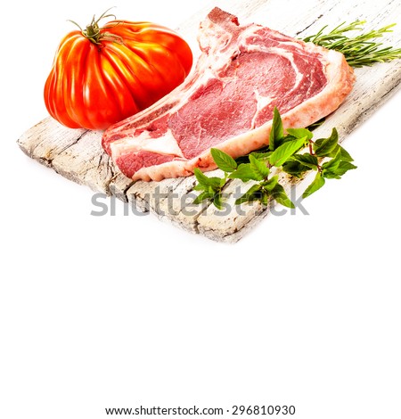 meat, a large pieces of fresh meat, beef, to be on the white board, decorated with greens and Fresh big tomato\
 isolated on white background