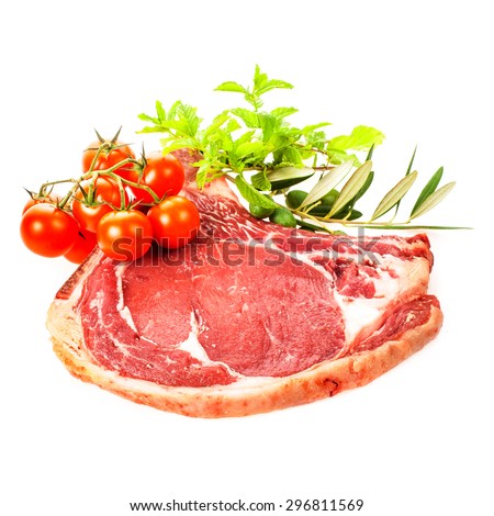 a large piece of fresh meat decorated with cherry tomatoes and fresh herbs\
Isolated on white background