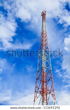 Telecommunication mast with microwave link and TV transmitter antennas over a blue sky.