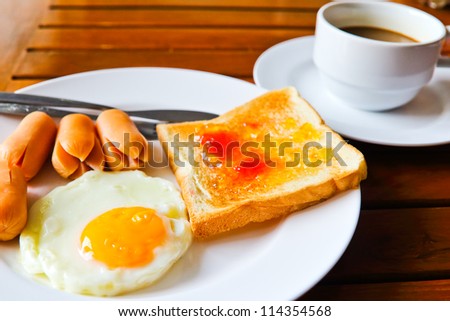 breakfast with fried eggs,sausage, toasts and coffee