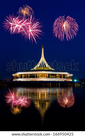 beautiful building with reflex on the lagoon against blue sky background with fireworks in public park, Suanluang Rama 9, Thailand