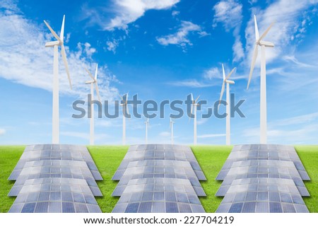 Solar panels and wind turbine on green grass field against blue sky background,useful for carbon credits concept.