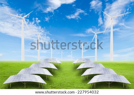 Solar panels and wind turbine on green grass field against blue sky background,useful for carbon credits concept.