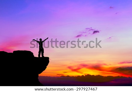 Silhouette of a man on the rock at sunset