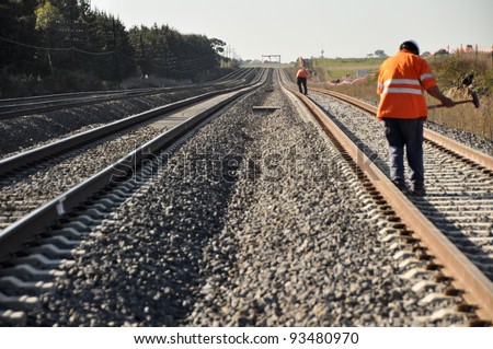 Railway Workers loosening railway on hot summer day