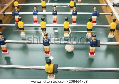 the blue and the yellow team are ready for battle in the table football bar sport