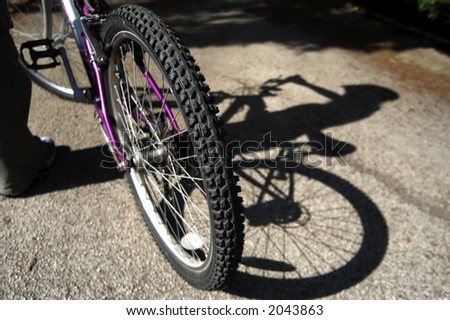 a shadow is cast from a youth with their bike