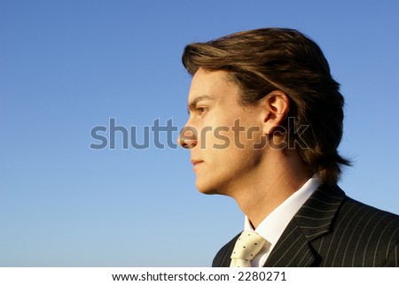 Businessman looking thoughtful against blue sky