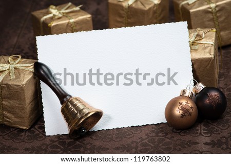 Greeting card for Christmas with brown Christmas ball, presents and bell
