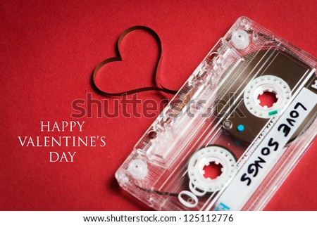 Valentines day card - audio cassette with magnetic tape in shape of heart on red background