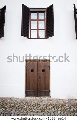 locked wooden door and opened windows on old house