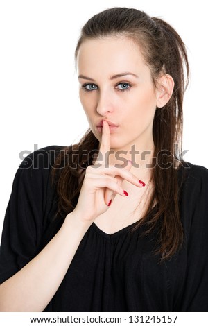 Speak no evil - attractive young brunette with finger on her lips, isolated on white background