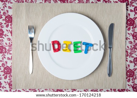 Concept: healthy food and diet - word DIET on a white plate