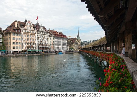 LUCERNE, SWITZERLAND - SEPTEMBER 6, 2014: Chapel Bridge and Hotels on the Reuss River, Lucerne. The Chapel Bridge spans the Reuss with the Hotel Des Alpes and Mr. Pickwick Pub in background