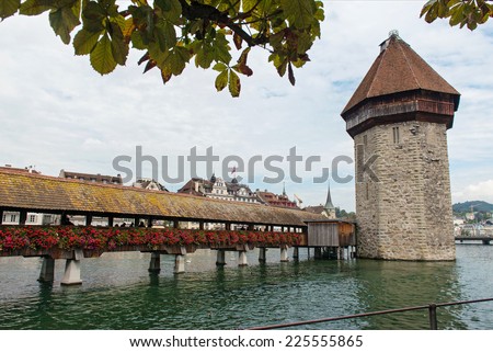 LUCERNE, SWITZERLAND - SEPTEMBER 6, 2014: Chapel Bridge with Reuss River in Luzern, Switzerland. The bridge was restored in 2002 after the terrible fire which broke out in 1993.