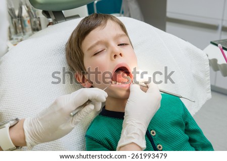 little boy opening his mouth wide during inspection of oral cavity