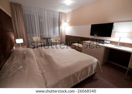 wide angle picture of interior hotel room - huge bed for two with flat TV in front
