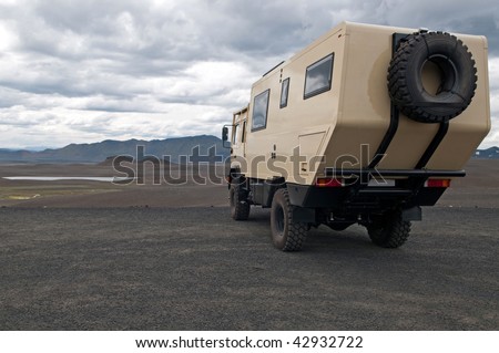 huge tourist exploration truck parked in front of beautiful volcanic landscape of Iceland