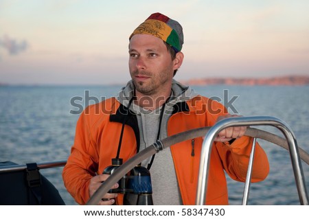 young man on the yacht during vacation with beautiful sunset in the background