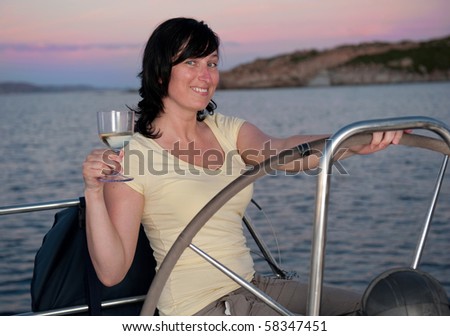 young woman on the yacht with glass of wine