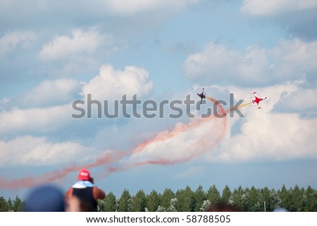 KECSKEMET, HUNGARY - AUGUST 8: spectators watch crossover of two airplanes of Turkish Stars display team at Airshow August 8, 2010 in Kecksemet, Hungary