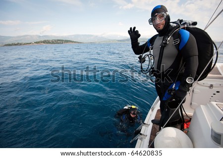 scuba diver standing on the yacht and ready to dive