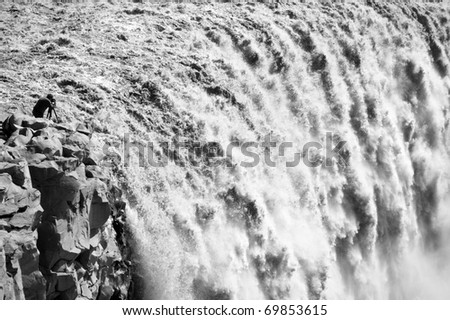 photographer taking picture of largest waterfall in Europe - Dettifoss from close distance, Iceland (black and white picture)