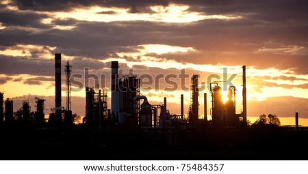 silhouette of oil refinery at sunset