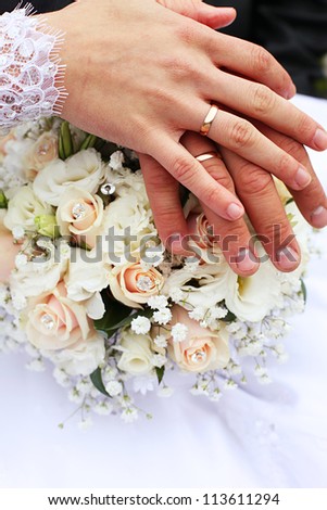 Hands with wedding rings amd bouquet