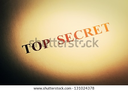 Top secret text on folder in hard light. Selective focus.