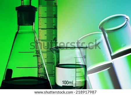 Laboratory glassware in green light. Science concept.