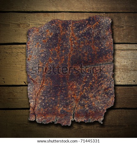 Rusty metal plate on wood wall