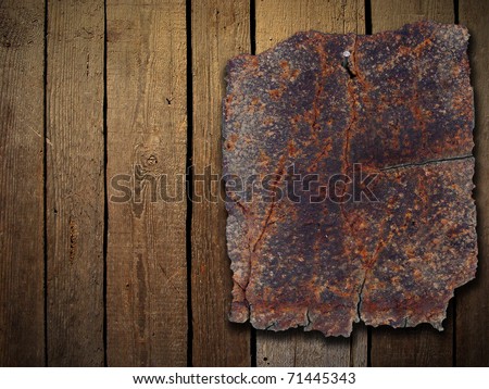 Rusty metal plate on wood wall