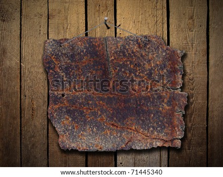 Rusty metal plate on wood wall with wire