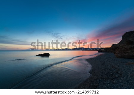 sunset with beautiful clouds reflected in the calm water of the ocean