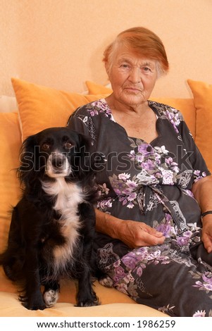 The grandmother with a dog sit on a sofa